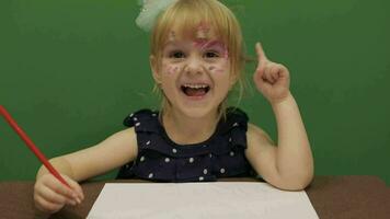 menina sentado às a mesa. Educação processo. fofa menina sorridente. croma chave video