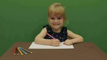 meisje zittend Bij de tafel. onderwijs werkwijze. schattig meisje lachend. chroma sleutel video