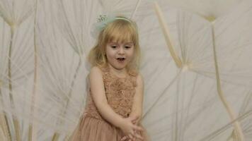 Happy three years old girl make faces and dancing. Cute blonde child video