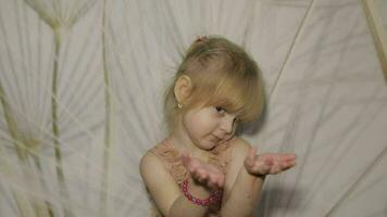 Lycklig tre år gammal flicka göra ansikten och dans. söt blond barn video