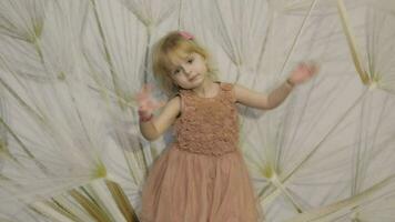 Happy three years old girl make faces and dancing. Cute blonde child video