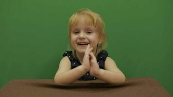 Girl sitting at the table. Education process. Cute girl smiling. Chroma Key video