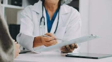 Friendly cheerful nurse or doctor at modern clinic talking to patient. Happy physician or gynaecologist holding clipboard, smiling and giving medical consultation to young woman. Health concept video