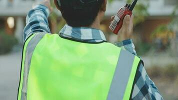 A team of construction engineers talks to managers and construction workers at the construction site. Quality inspection, work plan, home and industrial building design project video