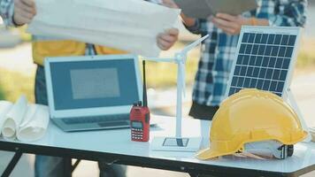 een team van bouw ingenieurs praat naar managers en bouw arbeiders Bij de bouw plaats. kwaliteit inspectie, werk plan, huis en industrieel gebouw ontwerp project video