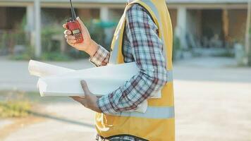 un equipo de construcción ingenieros negociaciones a gerentes y construcción trabajadores a el construcción sitio. calidad inspección, trabajo plan, hogar y industrial edificio diseño proyecto video