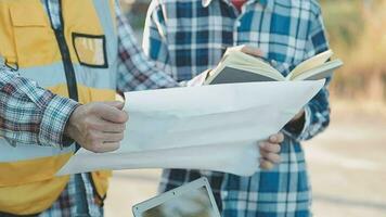 A team of construction engineers talks to managers and construction workers at the construction site. Quality inspection, work plan, home and industrial building design project video