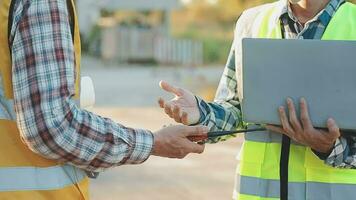 A team of construction engineers talks to managers and construction workers at the construction site. Quality inspection, work plan, home and industrial building design project video