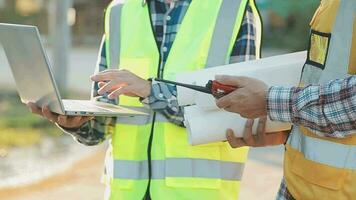 un equipo de construcción ingenieros negociaciones a gerentes y construcción trabajadores a el construcción sitio. calidad inspección, trabajo plan, hogar y industrial edificio diseño proyecto video