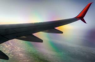 airplane wing in flight above clouds with optical effect photo