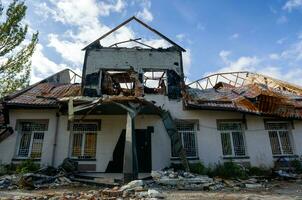 destruido y quemado casas en el ciudad durante el guerra en Ucrania foto