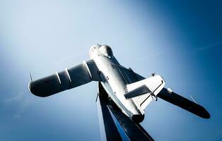 monument of an old military aircraft against the blue sky photo