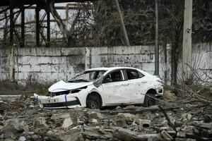 coche y destruido edificios de el taller de el azovstal planta en mariupol foto