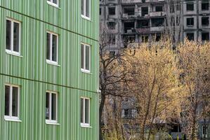 newly built house against the background of the destroyed and burned during the fighting in Ukraine photo