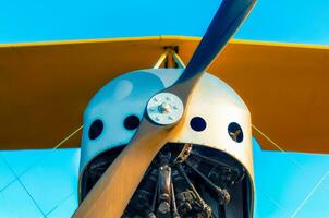 propeller with a motor and yellow wings of a vintage airplane photo