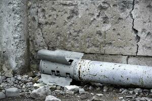 weapon rocket lying on the ground near the wall in Ukraine photo