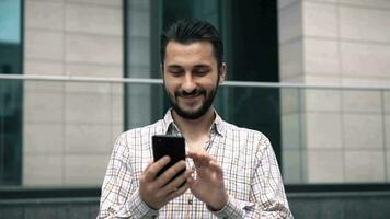 attractive caucasian young man looking at smartphone video