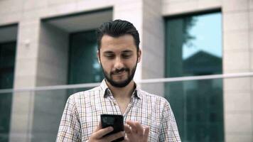 attractive caucasian young man looking at smartphone video