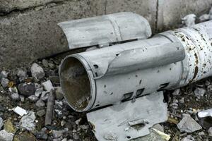 weapon rocket lying on the ground near the wall in Ukraine photo