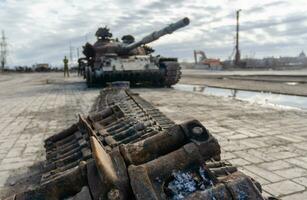 dañado militar tanque en un ciudad calle en Ucrania foto