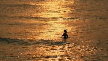 onda spruzzi nel Alba o tramonto su un' tropicale spiaggia. video