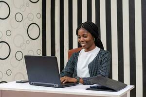 pretty african lady feeling happy as she works in the office photo