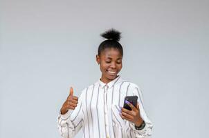 young pretty african lady feeling overexcited about what she saw on her sell phone photo