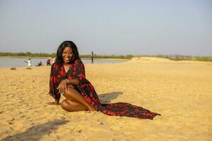 beautiful african woman portrait smiling at the beach photo