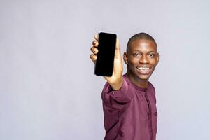 Black man showing blank cellphone screen ,empty space, mock up studio background photo