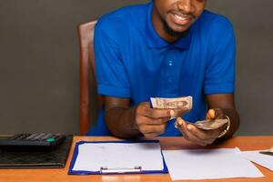 joven negro hombre haciendo algunos financiero cálculos foto