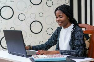 pretty african lady feeling happy as she works in the office photo