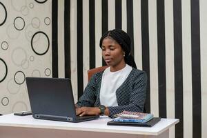 young beautiful african secretary working her laptop photo