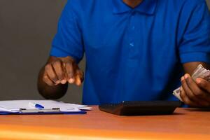 young african man doing some financial calculations photo