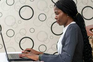 pretty african lady feeling happy as she works in the office photo