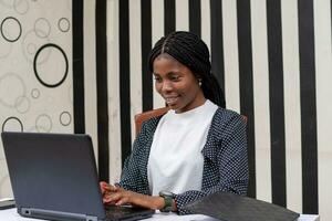 pretty african lady feeling happy as she works in the office photo