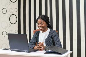 pretty african lady feeling happy as she works in the office photo