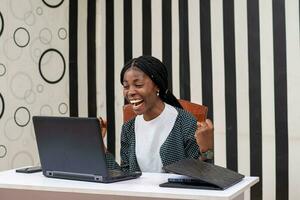 pretty african lady feeling happy as she works in the office photo