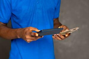 person using a calculator and holding some money photo