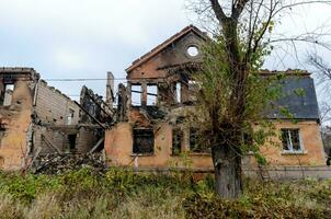 destroyed and burned houses in the city during the war in Ukraine photo