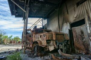 burnt military armored car on the street of the ruined city photo