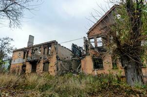 destroyed and burned houses in the city during the war in Ukraine photo