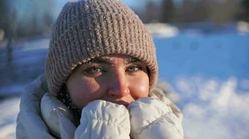 the girl is frozen and warms face. a woman looks into the camera in winter video