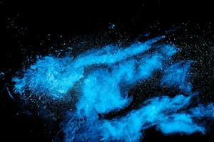 Blue powder explode cloud on black background. Launched blue dust particles splash on  background. photo