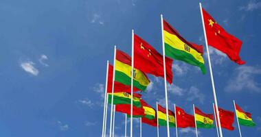 Bolivien und China Flaggen winken zusammen im das Himmel, nahtlos Schleife im Wind, Raum auf links Seite zum Design oder Information, 3d Rendern video