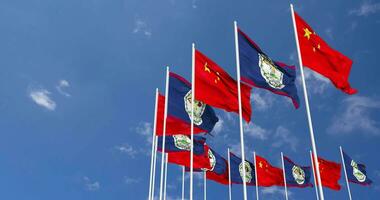 Belize et Chine drapeaux agitant ensemble dans le ciel, sans couture boucle dans vent, espace sur la gauche côté pour conception ou information, 3d le rendu video