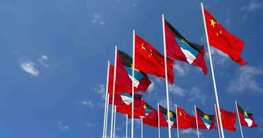 antigua y barbuda y China banderas ondulación juntos en el cielo, sin costura lazo en viento, espacio en izquierda lado para diseño o información, 3d representación video
