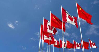 Canadá y China banderas ondulación juntos en el cielo, sin costura lazo en viento, espacio en izquierda lado para diseño o información, 3d representación video