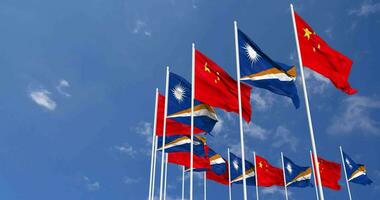 Marshall îles et Chine drapeaux agitant ensemble dans le ciel, sans couture boucle dans vent, espace sur la gauche côté pour conception ou information, 3d le rendu video
