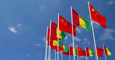 Guinea and China Flags Waving Together in the Sky, Seamless Loop in Wind, Space on Left Side for Design or Information, 3D Rendering video