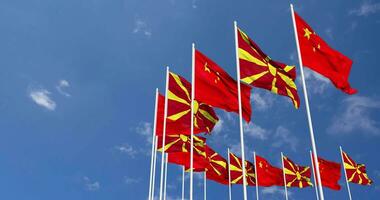 nord macedonia e Cina bandiere agitando insieme nel il cielo, senza soluzione di continuità ciclo continuo nel vento, spazio su sinistra lato per design o informazione, 3d interpretazione video